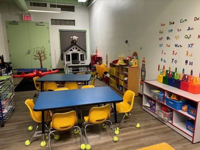 A classroom with tables and chairs, some yellow.