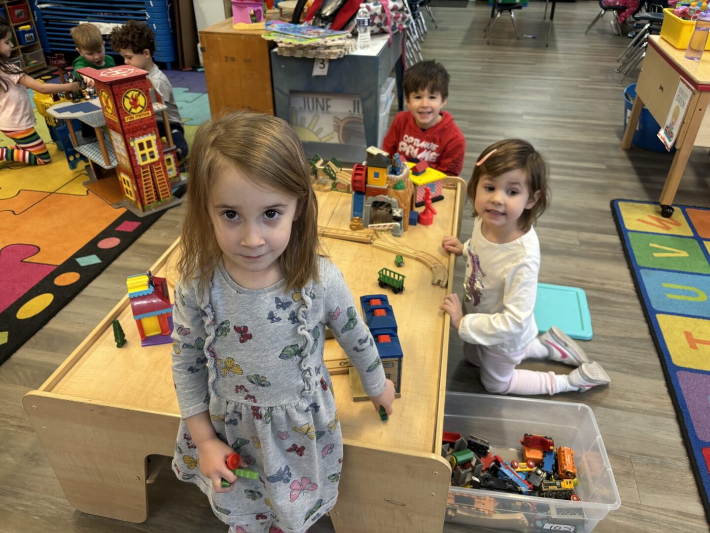 Three children are playing with toys in a room.